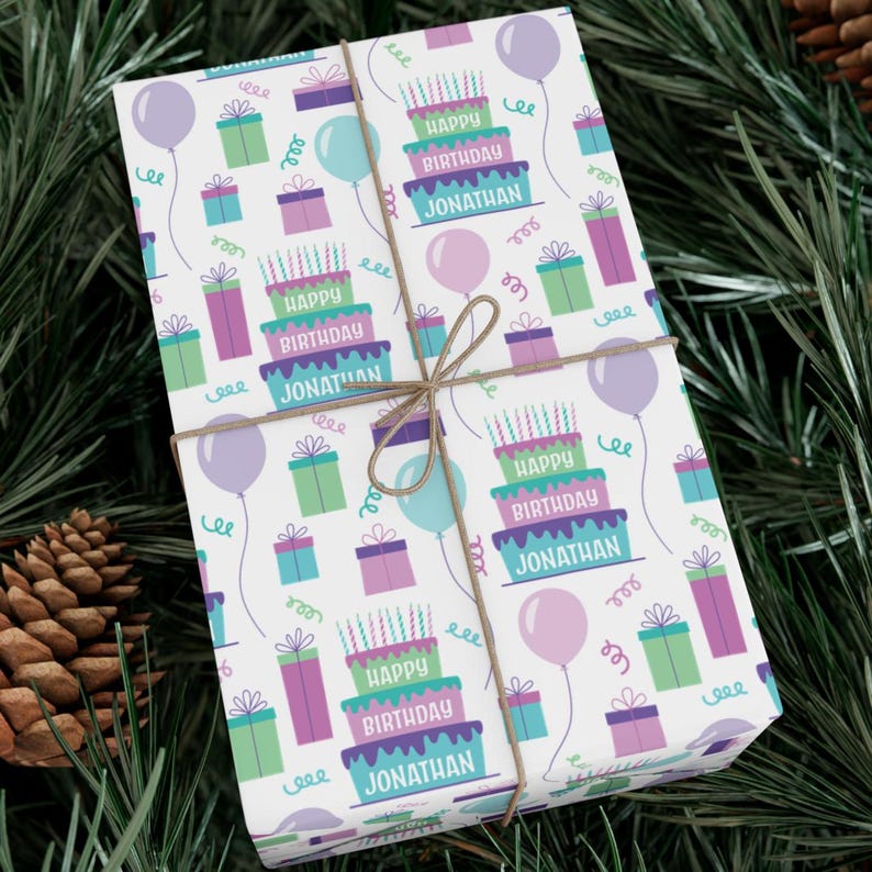 May include: White wrapping paper with a repeating pattern of colorful birthday cakes, presents, and balloons. The text "Happy Birthday Jonathan" is repeated on the cakes.