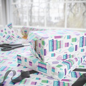 May include: White gift wrap with a repeating pattern of colorful birthday cakes, balloons, and presents. The text "Happy Birthday Jonathan" is repeated throughout the pattern.