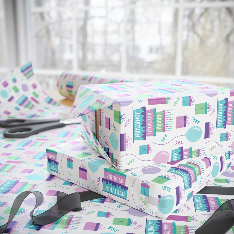 May include: White gift wrap with a repeating pattern of colorful birthday cakes, balloons, and presents. The text "Happy Birthday Jonathan" is repeated throughout the pattern.