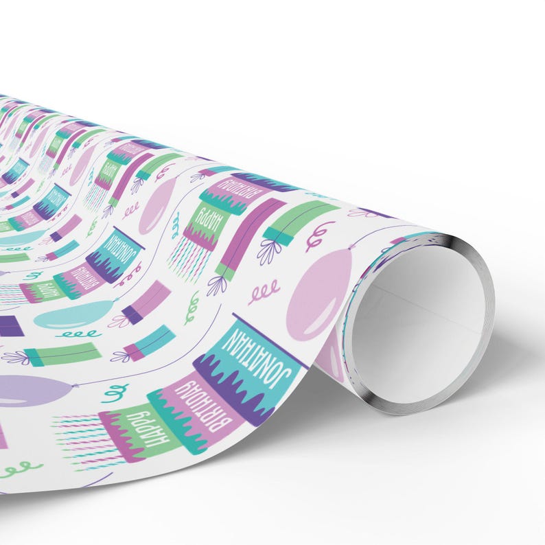 May include: White wrapping paper with a repeating pattern of birthday cakes, balloons, and presents. The cakes are decorated with green, purple, and pink frosting and candles. The balloons are pink and the presents are green and purple. The text "Happy Birthday Jonathan" is repeated throughout the pattern.