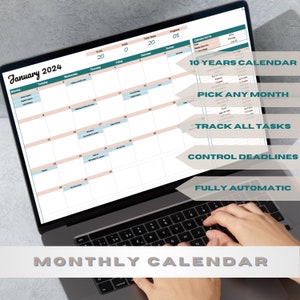 May include: A laptop computer displaying a digital calendar for January 2024. The calendar is designed to track tasks, control deadlines, and is fully automatic. The text on the screen reads "10 Years Calendar", "Pick Any Month", "Track All Tasks", "Control Deadlines", and "Fully Automatic". The laptop is on a gray surface and a person's hands are typing on the keyboard.