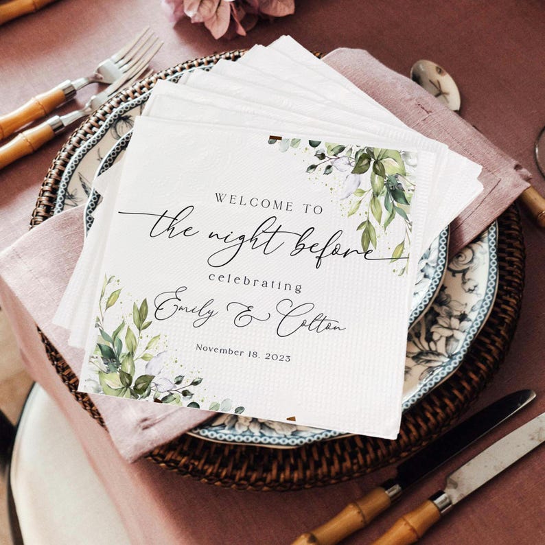 May include: White paper napkins with a green floral design and the text "Welcome to the night before celebrating Emily & Colton November 18, 2023".