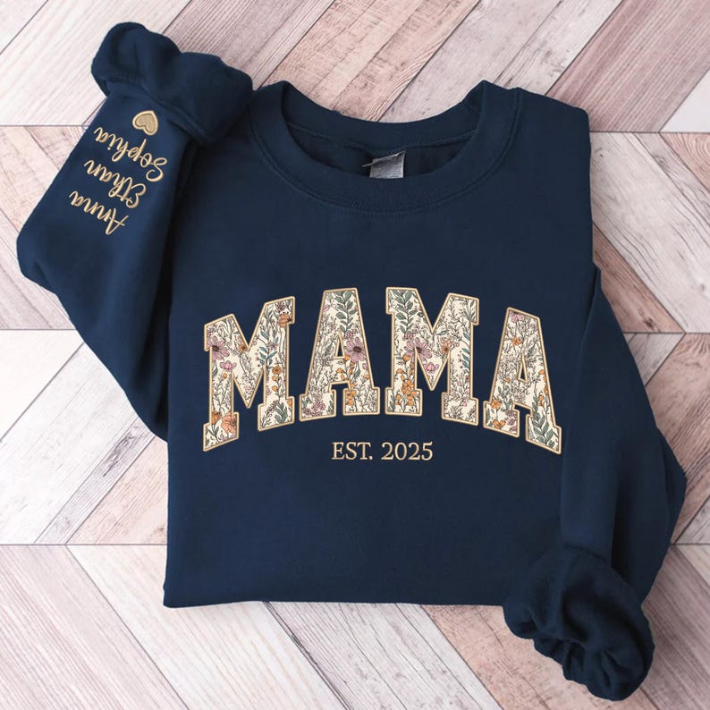 May include: Navy blue sweatshirt with a floral print "MAMA" design and the text "EST. 2025" in gold.