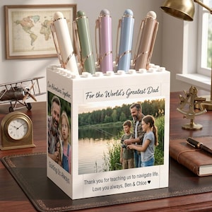 May include: A white block-style pen holder featuring custom photo prints of a father and children. The front displays a fishing scene with the text For the World's Greatest Dad and a thank you message. The side shows a portrait with the text Our Adventures Together.