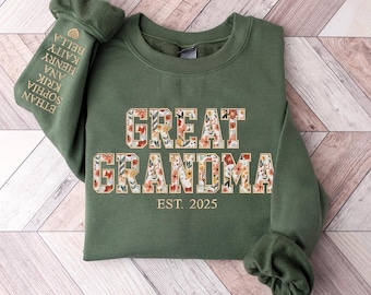 Op de afbeelding: Een groen sweatshirt met de tekst "GREAT GRANDMA EST. 2025" in gouden letters met bloemmotieven. De tekst is in een lettertype in varsity-stijl.
