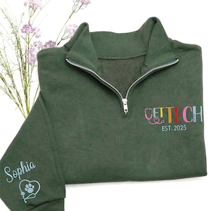 May include: Dark green quarter-zip sweatshirt with the embroidered text "VET TECH" in colorful letters and a stethoscope and heart design. The sleeve features the name "Sophia" and a paw print heart design. The text "EST. 2025" is also embroidered.
