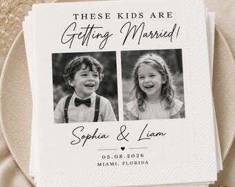 Op de afbeelding: Een stapel witte vierkante papieren servetten met de tekst THESE KIDS ARE Getting Married! boven twee zwart-witfoto's van een jonge jongen en een meisje. Onder de foto's staan de namen Sophia & Liam, een hartje en 05.08.2026 MIAMI, FLORIDA.
