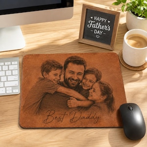 May include: A rectangular brown leather mouse pad featuring a laser-engraved portrait of a parent hugging two children. The text "Best Daddy" is engraved in a cursive script at the bottom center of the mouse pad surface.