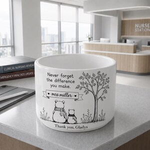 May include: White ceramic planter with a black and white illustration of two bears under a tree. The planter has the text "Never forget the difference you make. - mrs.miller - Thank you, Gladys."