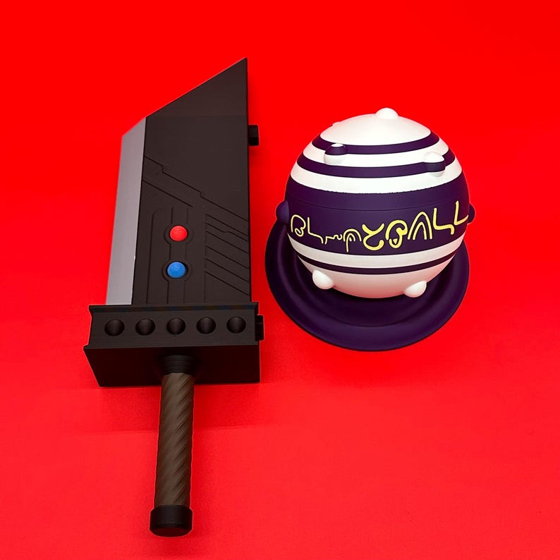 May include: A black and gray sword with red and blue buttons, and a brown handle, next to a white and purple striped sphere with text on a purple base, set against a red background.