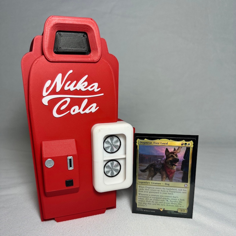 May include: A red and white 3D printed Nuka Cola vending machine with a white door and a black slot. The vending machine is next to a black card with a golden border. The card features a dog with a red bandana and the text "Dogmeat, Ever Loyal".