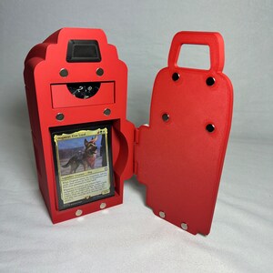 May include: Red, hinged, magnetic box with a drawer and a compartment for a trading card game deck. The box is open and a card with a dog on it is visible. The card reads "Dogmeat,  Very Loyal".