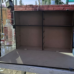 Op de afbeelding: Open houten doos met drie planken. De doos is gemaakt van donker hout en heeft een zwarte afwerking. De planken zijn leeg.