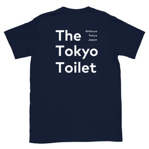 May include: A navy blue t-shirt with white text that reads "The Tokyo Toilet" and "Shibuya Tokyo Japan" in smaller font.