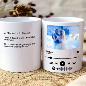 May include: White ceramic mug with lyrics from Ed Sheeran's "Perfect" and a photo of a couple. The mug also features a music player graphic, the song title, and the artist's name.