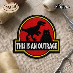 Può includere: Toppa ricamata con silhouette nera di dinosauro e gatto su sfondo rosso, bordata di giallo. Il testo "THIS IS AN OUTRAGE" è in bianco. La toppa è etichettata "PATCH".
