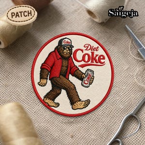 Op de afbeelding: Geborduurde patch met een Bigfoot-achtig wezen in een rode jas en een Coke-pet, met een Diet Coke-blikje. Het ontwerp heeft een crèmekleurige achtergrond met rode rand en de woorden "Diet Coke".