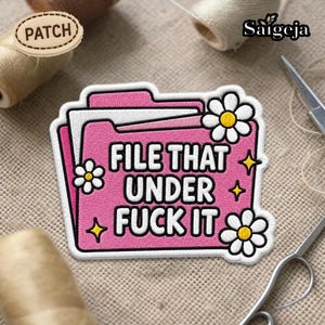 Puede incluir: Parche bordado rosa con el texto "FILE THAT UNDER FUCK IT" en negro. El parche presenta un diseño de carpeta con margaritas blancas y acentos de estrellas amarillas. La palabra "PATCH" está en una etiqueta de madera.