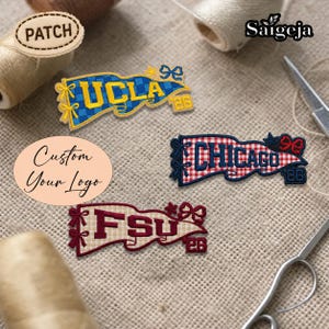 Könnte beinhalten: Gestickte Wimpel-Patches mit "UCLA", "CHICAGO" und "FSU" in Gelb, Weiß und Bordeauxrot, mit dekorativen Schleifen und der Zahl "26". Die Patches befinden sich auf einem beigefarbenen Stoffhintergrund. Das Wort "PATCH" befindet sich auf einem runden Patch.