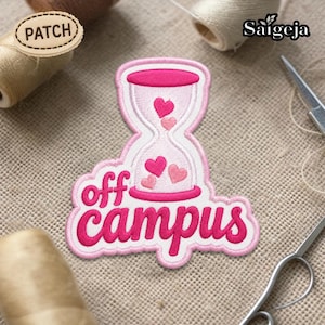 Pode incluir: Patch bordado com um design de ampulheta rosa e três corações rosa. As palavras "off campus" estão escritas em itálico abaixo da ampulheta. O patch tem uma borda branca e está em um fundo bege.