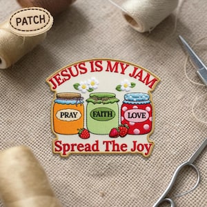 Puede incluir: Parche bordado con tres tarros de mermelada etiquetados "Pray", "Faith" y "Love". El parche dice "Jesus is my Jam" y "Spread The Joy". Los tarros son naranjas, verdes y rojos con lunares blancos. También se presentan fresas y flores.