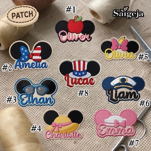 May include: A collection of embroidered patches in the shape of Mickey Mouse ears, each with a different design and name. Designs include an apple, sunglasses, a bow, a hat, and a sailor hat. Names include Oliver, Amelia, Ethan, Charlotte, Olivia, Liam, Emma, and Lucas.