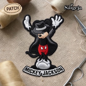 May include: Embroidered patch featuring a cartoon mouse in a black outfit, hat, and white gloves, with the text "Mickey Jackson" on a curved banner. The patch has a red and white color scheme and is likely for clothing or accessories.