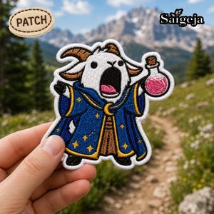 May include: Embroidered patch featuring a cartoon goat in a blue wizard robe, holding a potion bottle. The patch has a white border and the word "PATCH" on a separate patch. The background shows a mountain landscape.