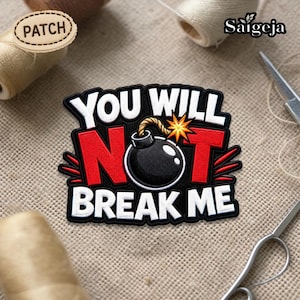 May include: A black, red, and white patch with the text "YOU WILL NOT BREAK ME" and a cartoon bomb illustration. The patch is surrounded by sewing supplies, including thread and scissors.