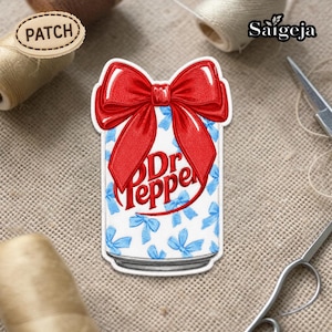 May include: Embroidered patch featuring a Dr Pepper can design with a large red bow on top. The can is white with blue bows and the Dr Pepper logo in red. The patch is surrounded by sewing supplies.