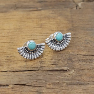 May include: A pair of silver earrings with turquoise stones. The earrings have a fan-shaped design.