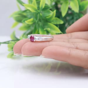 May include: A white ceramic mug with a black handle and the text "But First, Coffee" in a bold, black font. The mug is set against a blurred background, suggesting a cozy setting. The mug appears to be approximately 4 inches tall.