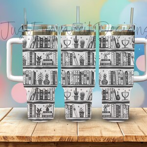 Puede incluir: Tres vasos de acero inoxidable con fondo blanco e ilustraciones en negro y gris de libros en estanterías. Los vasos tienen una tapa dorada y una pajita.