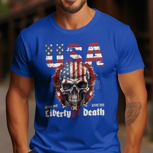 May include: A blue t-shirt featuring a skull graphic. The skull is decorated with the American flag and the text "USA 1776 Give Me Liberty or Death".