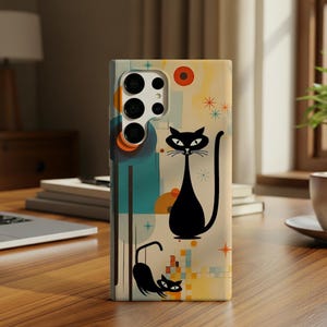 Puede incluir: Una funda de teléfono con un diseño retro que presenta dos siluetas de gatos negros sobre un fondo crema. La funda tiene una estética moderna de mediados de siglo con formas geométricas, estrellas y una paleta de colores naranja, turquesa y amarillo.