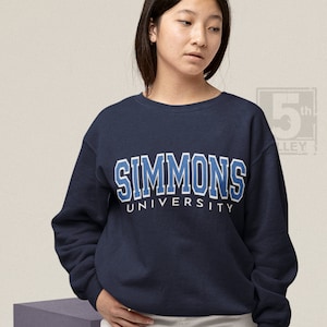Puede incluir: Sudadera azul marino con el texto "SIMMONS UNIVERSITY" en blanco con contornos azules.