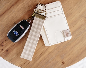 Cartera tarjetero de piel sintética con llavero y cordón para la muñeca.