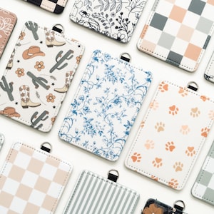 Puede incluir: Una colecci&oacute;n de tarjeteros rectangulares con varios dise&ntilde;os. Los dise&ntilde;os incluyen flores, huellas de patas, rayas y un tema del oeste con cactus y botas de vaquero. Cada uno tiene un lazo negro en la parte superior.