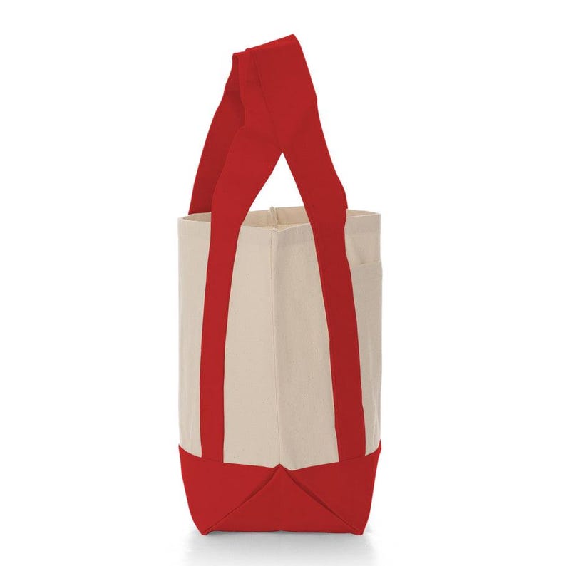 May include: A canvas tote bag with a rectangular shape. The bag features a cream-colored body with red accents on the bottom and handles. The handles are long and extend from the bottom to the top of the bag.