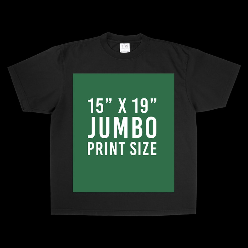 May include: A black short-sleeve t-shirt featuring a large, centered green rectangular graphic. The graphic contains white text that reads 15" X 19" JUMBO PRINT SIZE, indicating the dimensions of the available print area on the garment.