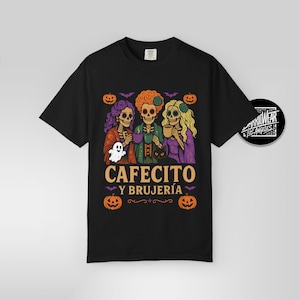 May include: Black t-shirt featuring a Halloween-themed graphic. The design includes three skeleton figures, pumpkins, bats, and the text "CAFECITO Y BRUJER&Iacute;A". A ghost and a black cat are also present in the illustration.