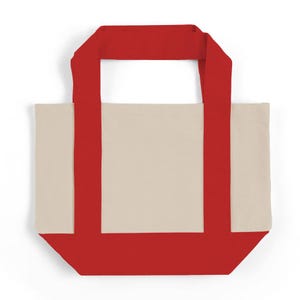 May include: A canvas tote bag with a cream-colored body and vibrant red accents. The bag features red handles and a red base, creating a striking contrast. This reusable tote is perfect for carrying groceries or everyday essentials.