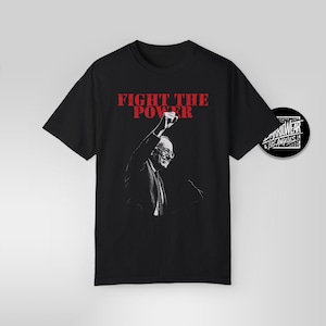 May include: Black t-shirt featuring a white image of a man raising his fist in the air. The text "FIGHT THE POWER" is printed in red above the image.