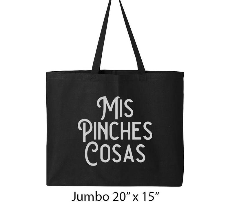 K&ouml;nnte beinhalten: Schwarze Tragetasche mit dem Text "Mis Pinches Cosas" in wei&szlig;er Schrift. Die Tasche ist mit "Jumbo 20" x 15"" beschriftet und hat zwei schwarze Griffe. Die Tasche besteht aus einem robusten Material und ist zum Tragen von Gegenst&auml;nden bestimmt.