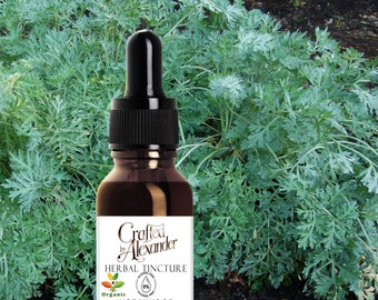 May include: A brown glass bottle with a dropper top, labeled "Crafted by Alexander Herbal Tincture Organic Wormwood". The bottle is in front of a green leafy plant.