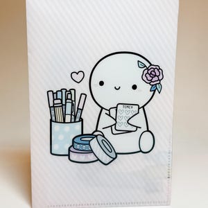 May include: A white ceramic mug with a black handle and the text "But First, Coffee" in a black, handwritten-style font. The mug is on a white surface.