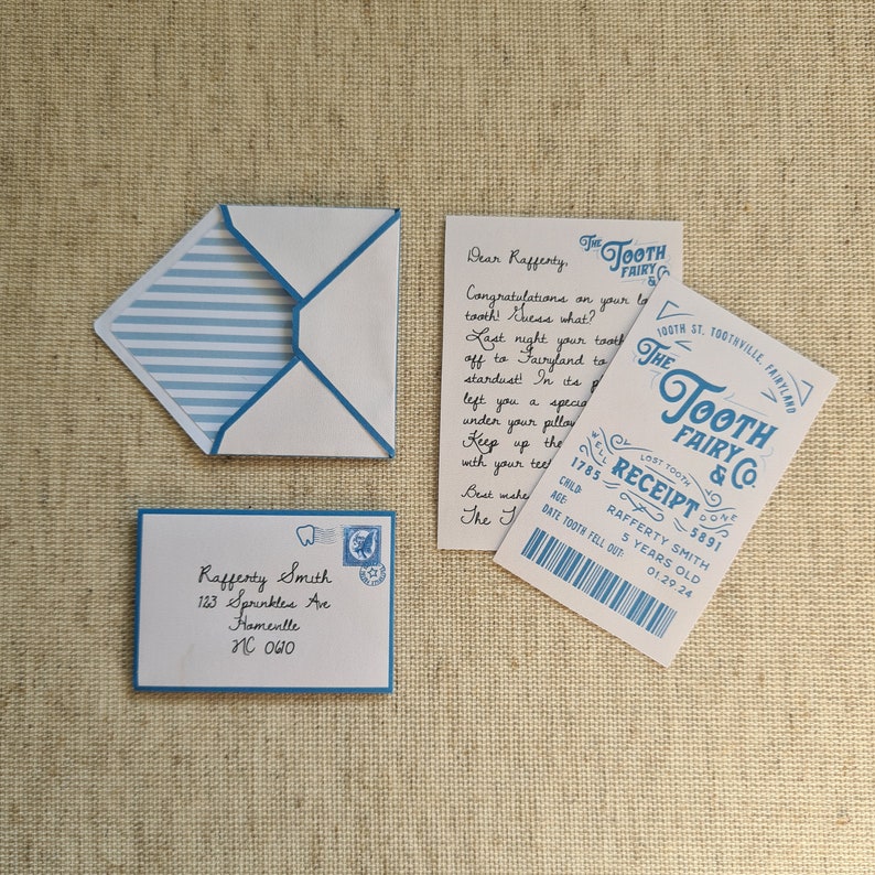 May include: A blue and white striped envelope with a blue border, a white envelope with blue writing, and a blue and white card with the text "The Tooth Fairy & Co. Receipt" and the text "Lost Tooth Done 1785 5891 Rafferty Smith 5 Years Old 01.29.24".