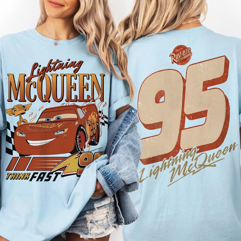 May include: Pale blue t-shirt featuring Lightning McQueen from the Cars film. The front graphic includes the character's image and the text "Lightning McQueen" and "Think Fast". The back displays a large "95" and "Lightning McQueen".