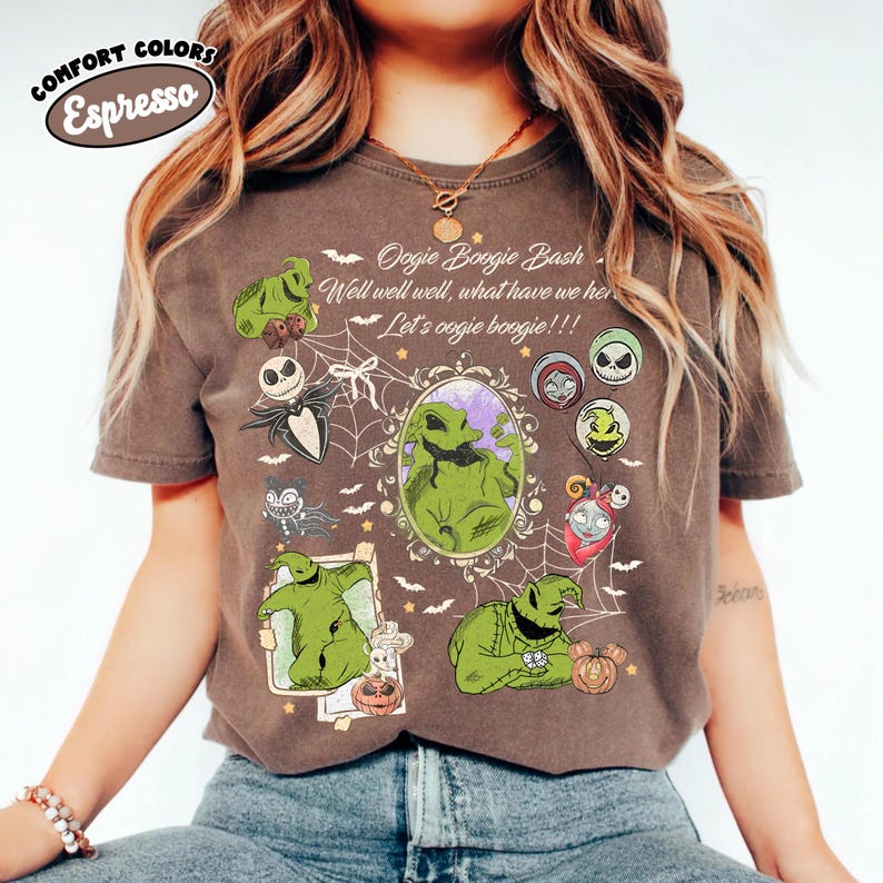 May include: Espresso-colored t-shirt featuring a graphic design with the text "Oogie Boogie Bash" and various cartoon characters. The design includes green characters, a spider web, and the phrase "Let's oogie boogie!!!".