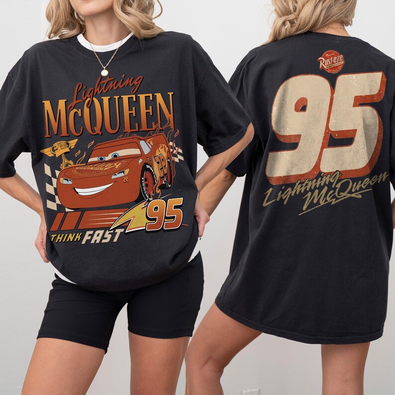 May include: Black t-shirt featuring Lightning McQueen from the movie Cars. The front graphic shows McQueen with the text "Lightning McQueen", "95", and "Think Fast". The back of the shirt displays "95" and "Lightning McQueen".